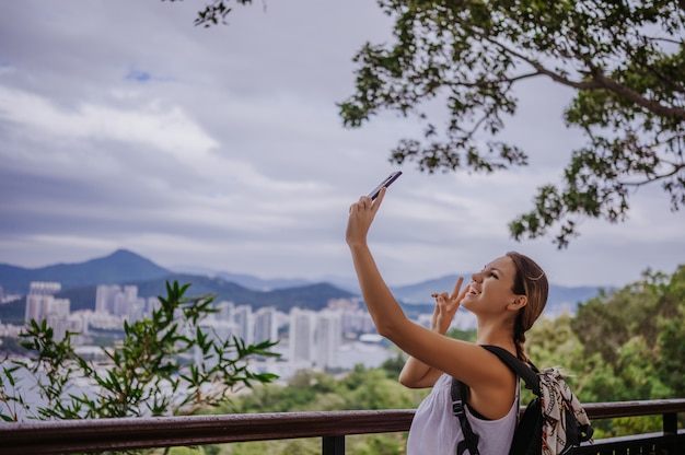 Premium Photo Traveler Blonde Backpacker Woman Walking Taking Photos From Observation Deck Overlooking The Downtown Travel Adventure In China Tourist Beautiful Destination Asia Summer Holiday Vacation Trip