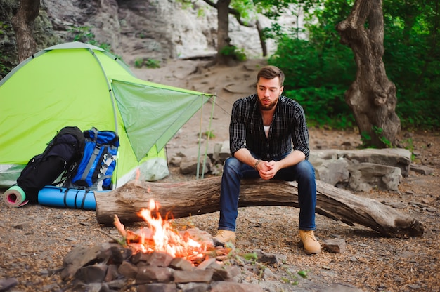 Premium Photo | Traveler man relaxing, looking at the fire and dreaming ...