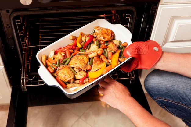 Tray of food being put into oven to cook Free Photo