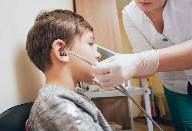 Treatment and warming-up the ears of a young boy. modern ...