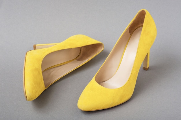 Premium Photo | Trendy color pair of yellow suede shoes on gray background