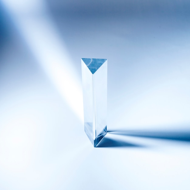 Triangular transparent prism with shadow on blue backdrop | Free Photo