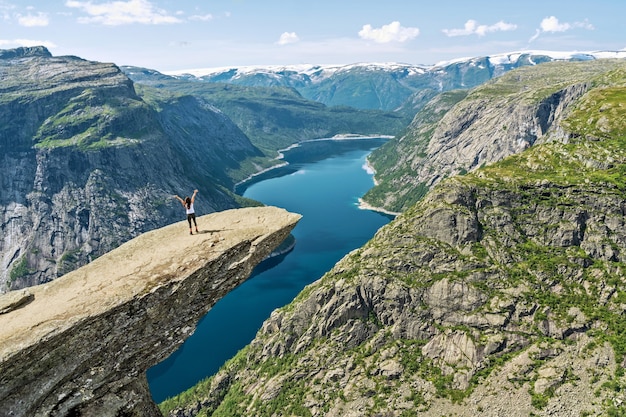 Ringedalsvatnet山の湖の上のトロルトゥンガ岩 岩の上に立っている女の子とノルウェーの有名なハイキング観光のランドマーク ノルウェー プレミアム写真