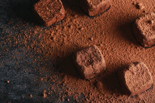 ココアをまぶしたトリュフ 暗い茶色の背景にココアパウダーで暗いチョコレート菓子 プレミアム写真
