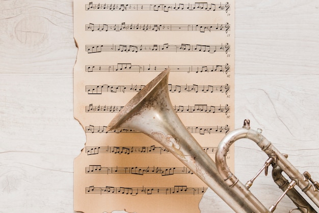 Trumpet on old page of sheet music Free Photo
