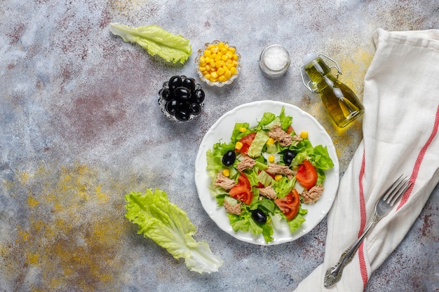 Tuna salad with lettuce,olives,corn,tomatoes,top view Free Photo