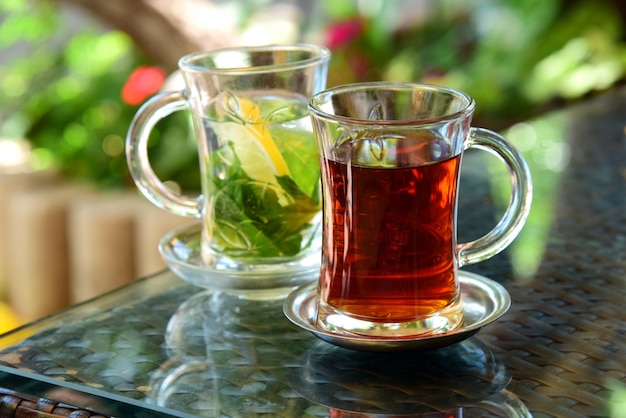 Premium Photo | Turkish tea and mint tea with lemon in glass cups on glass table