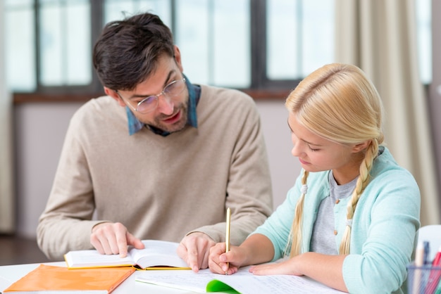 Tutor and girl at home writing new information Free Photo