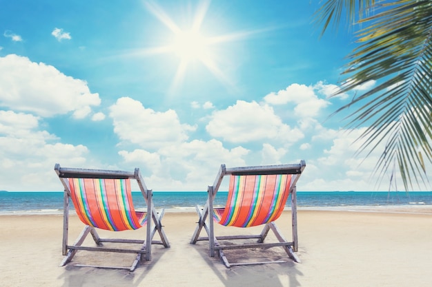 Premium Photo | Two beach chairs on palmbeach with sunny sky