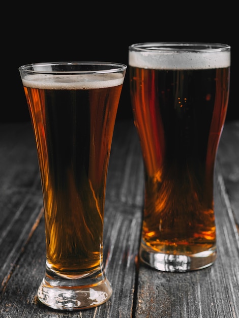 Premium Photo | Two beers on a dark wooden table