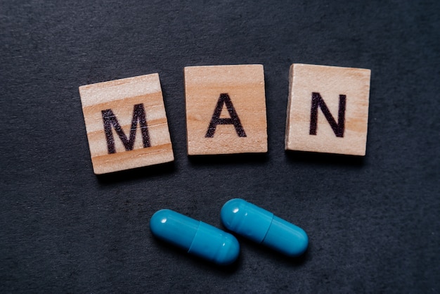 Premium Photo | Two Blue Capsules And The Inscription Man. Pills For ...