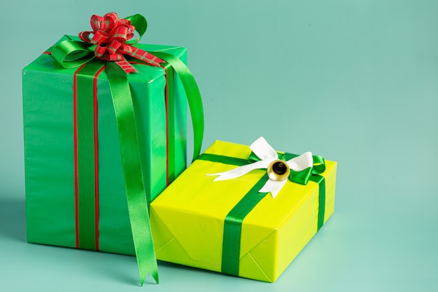薄緑色の背景に弓でプレゼントの2つのボックス 無料の写真