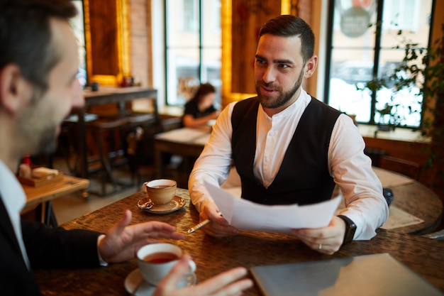 Premium Photo | Two businessmen meeting in cafe