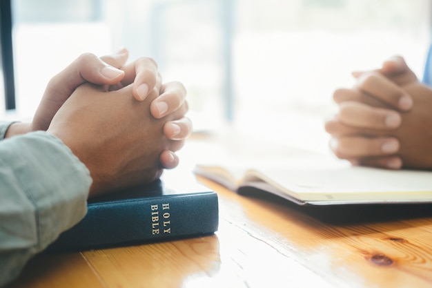 Premium Photo | Two christian people are praying together over holy bible.