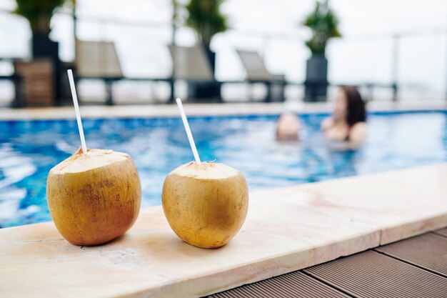 Download Premium Photo Two Coconut Cocktails With Drinking Straws On Edge Of Swimming Pool Of Spa Resort