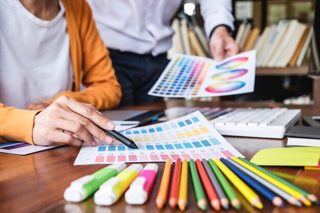 Two colleague creative graphic designer working on color selection and color swatches Premium Photo