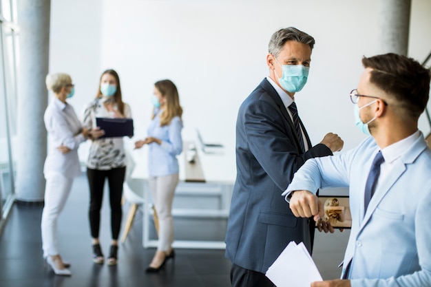 Premium Photo | Two colleagues avoid a handshake when meeting in the ...