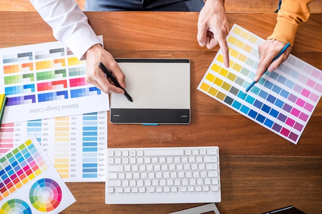 Two creative graphic designer working on color selection and swatches, drawing on graphics tablet Premium Photo