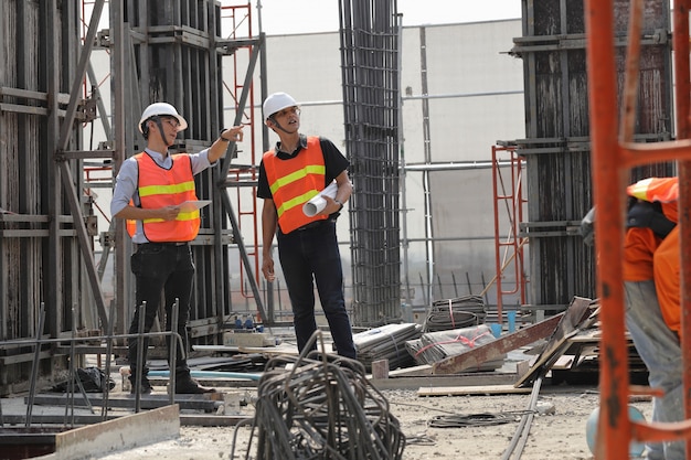 Two engineers work on the construction site. they are checking the