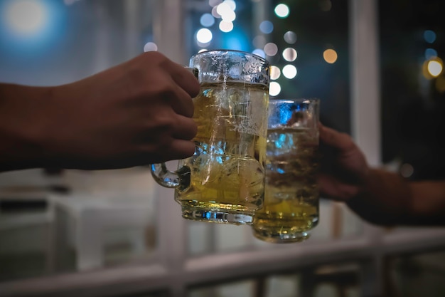 Premium Photo Two Friends Toasting With Glasses Of Light Beer At The Pub