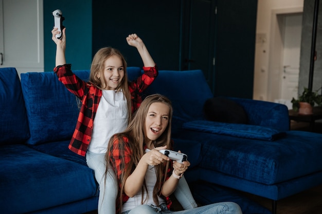 Premium Photo Two Girls Have Fun And Play A Console With A Joystick