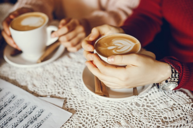 Two Girls Having Coffee While Studying A Music Score 