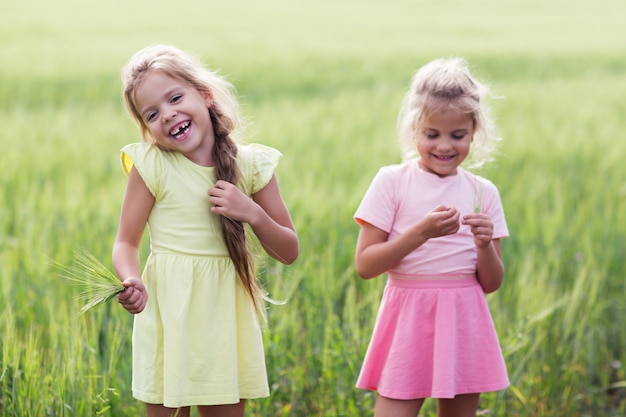 Premium Photo | Two girls laughing on a green field