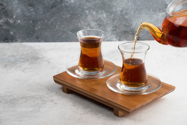 Free Photo Two Glass Cups Of Tea With Teapot On Wooden Board