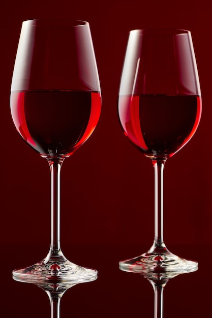 Premium Photo Two Glasses Of Red Wine On A Glossy Table