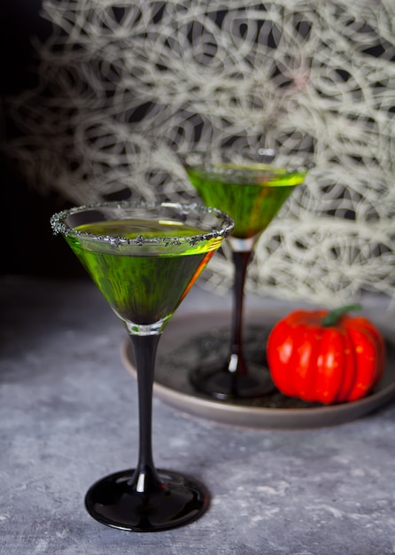 Premium Photo | Two glasses with green zombie cocktail for halloween ...