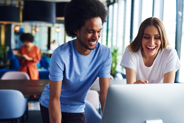 Premium Photo | Two happy coworkers working on computer