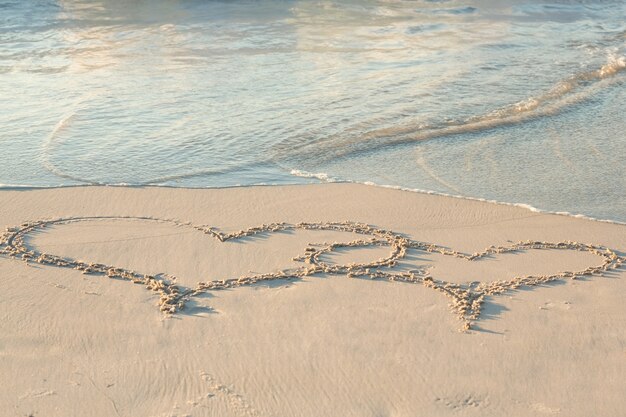 Premium Photo Two Hearts Drawn In The Sand