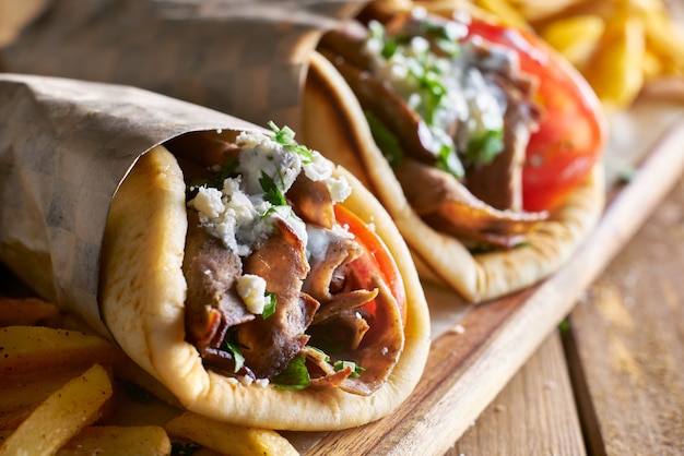 Premium Photo | Two lamb gyros with feta cheese and tzatziki sauce