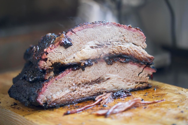 Premium Photo | Two large pieces of smoked brisket meat on a wooden ...