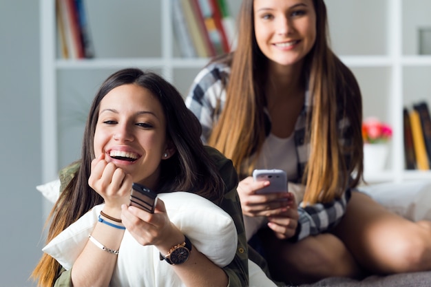 Premium Photo Two laughing girlfriends watching