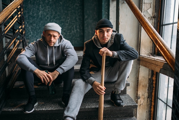 Premium Photo | Two male robbers are sitting on the stairs