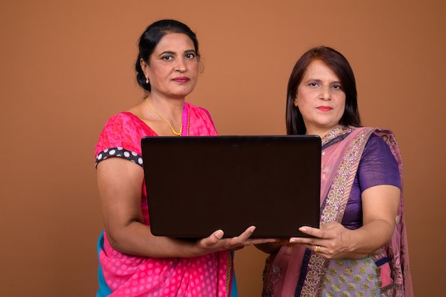 Two Mature Indian Women Reading Book Together Stock Photo