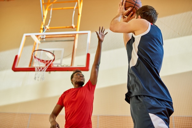 Premium Photo | Two men playing basketball in gym