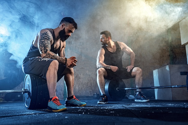 Premium Photo | Two muscular bearded tattoed athletes training at gym