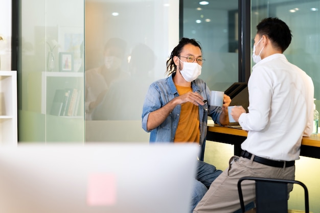 Premium Photo Two Office Workers Talking While Coffee Break In New Normal With Social Distance Practice Office They Wear Face Mask Reduce Risk To Infection Of Covid 19 Coronavirus As New Normal