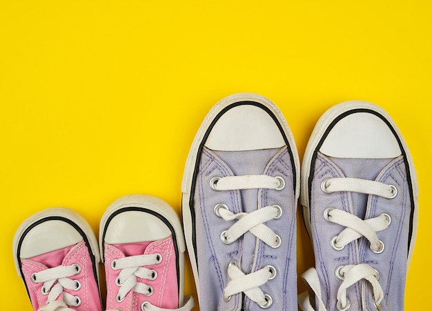 Premium Photo | Two pairs of worn textile shoes of different sizes on a ...