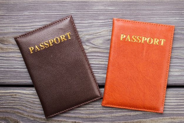 Premium Photo | Two passports on wood. brown and red passport on the desk.