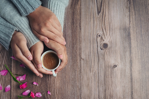 Free Photo Two People Holding Cup Of Coffee In Hands With Love And Warmth On Wooden Table