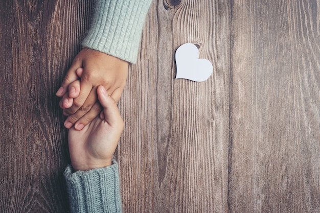 Free Photo Two People Holding Hands Together With Love And Warmth On Wooden Table
