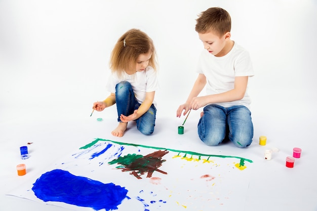 Premium Photo Two Pretty Child Friends Boy And Girl Are Drawing Pictures By Paints