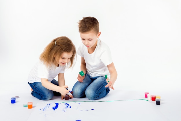 Premium Photo Two Pretty Child Friends Boy And Girl Are Drawing Pictures By Paints