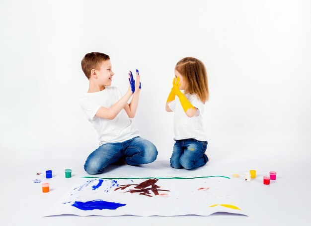 Premium Photo Two Pretty Child Friends Boy And Girl Are Drawing Pictures By Paints