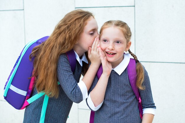 Две девочки целуются в школе на парте