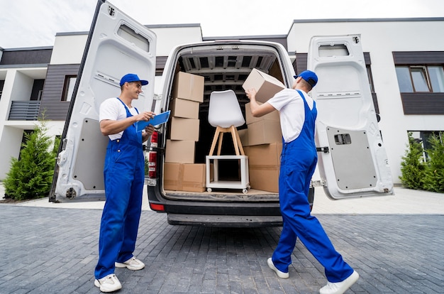 Premium Photo | Two removal company workers are loading boxes and ...