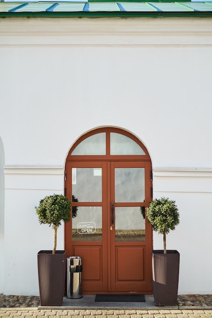 Two Small Decorative Trees Either Side Of A Front Door Entrance To Two Small Decorative Trees Either Side Of A Front Door Entrance To European Cafe Premium Photo